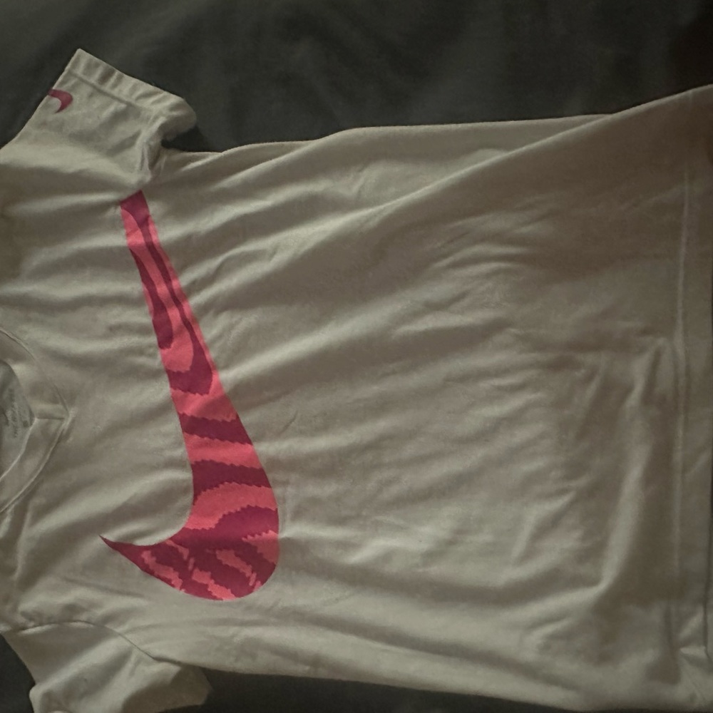 White Nike dri-for shirt with pink “swoosh” logo